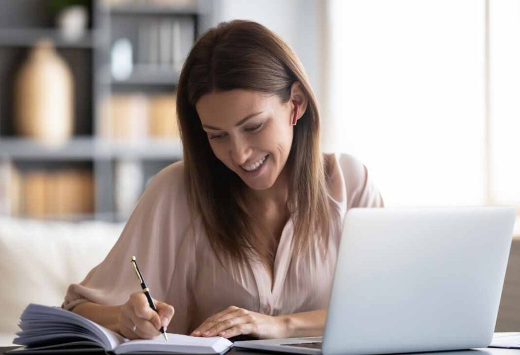 Woman at laptop taking notes