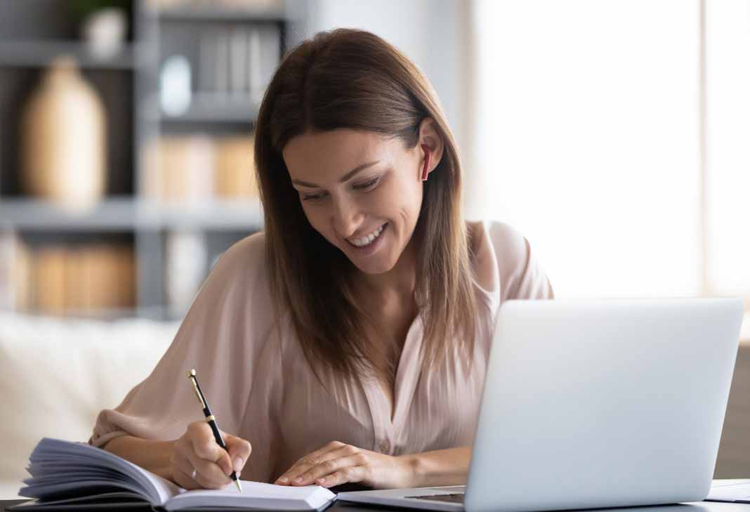 Woman at laptop taking notes